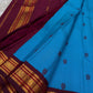 Electric peacock-blue Kanchipuram silk body showing fine Arakku hairline stripes and spaced floral silk buttas.