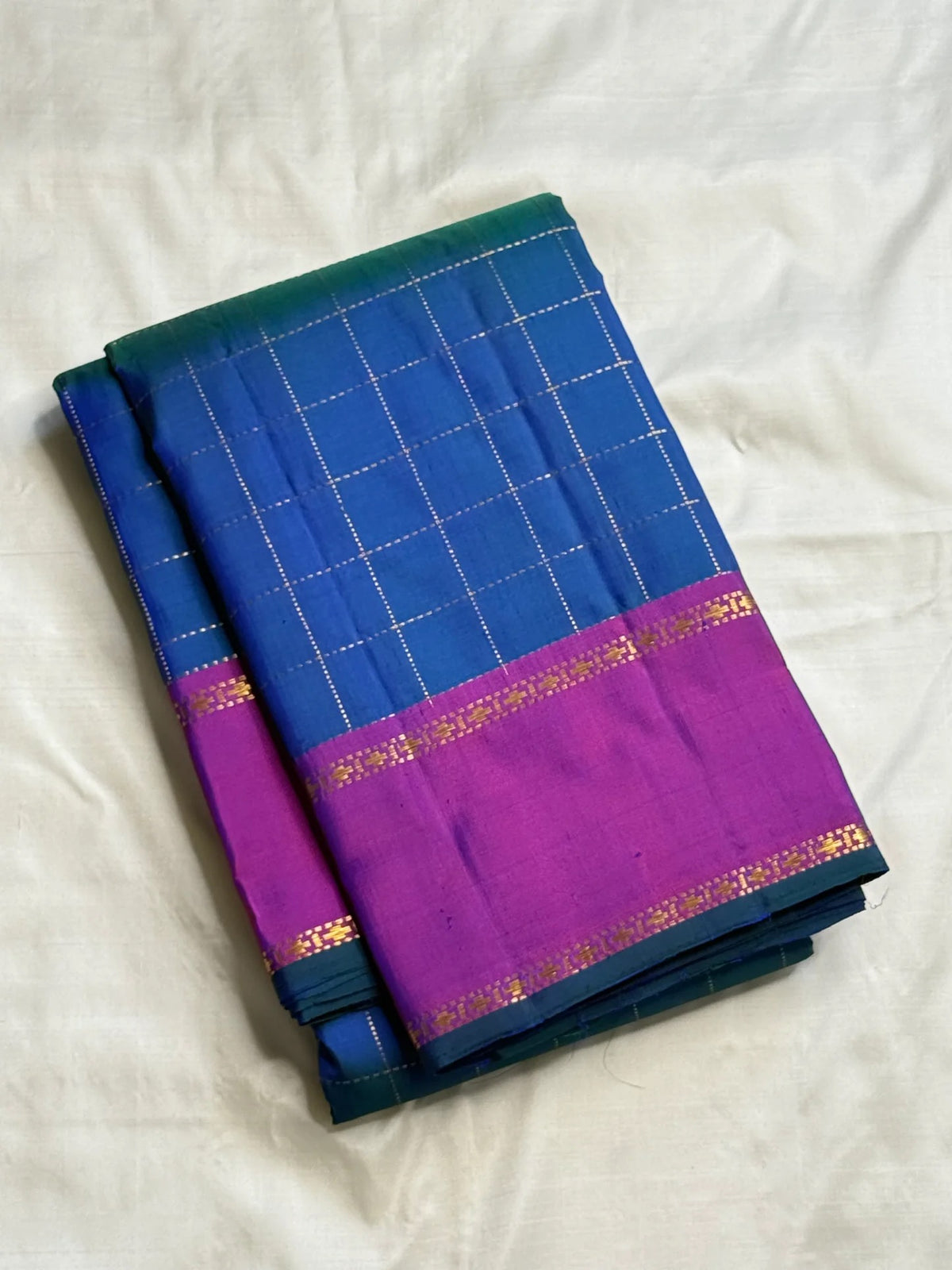 Blue silk Kanchipuram saree showing emerald-green colour play and fine gold checks