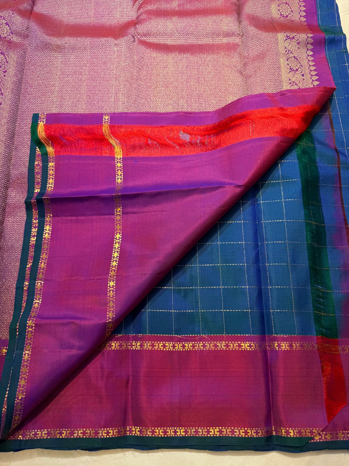 Close view of fine gold Zari Kattam lines crossing the blue silk body