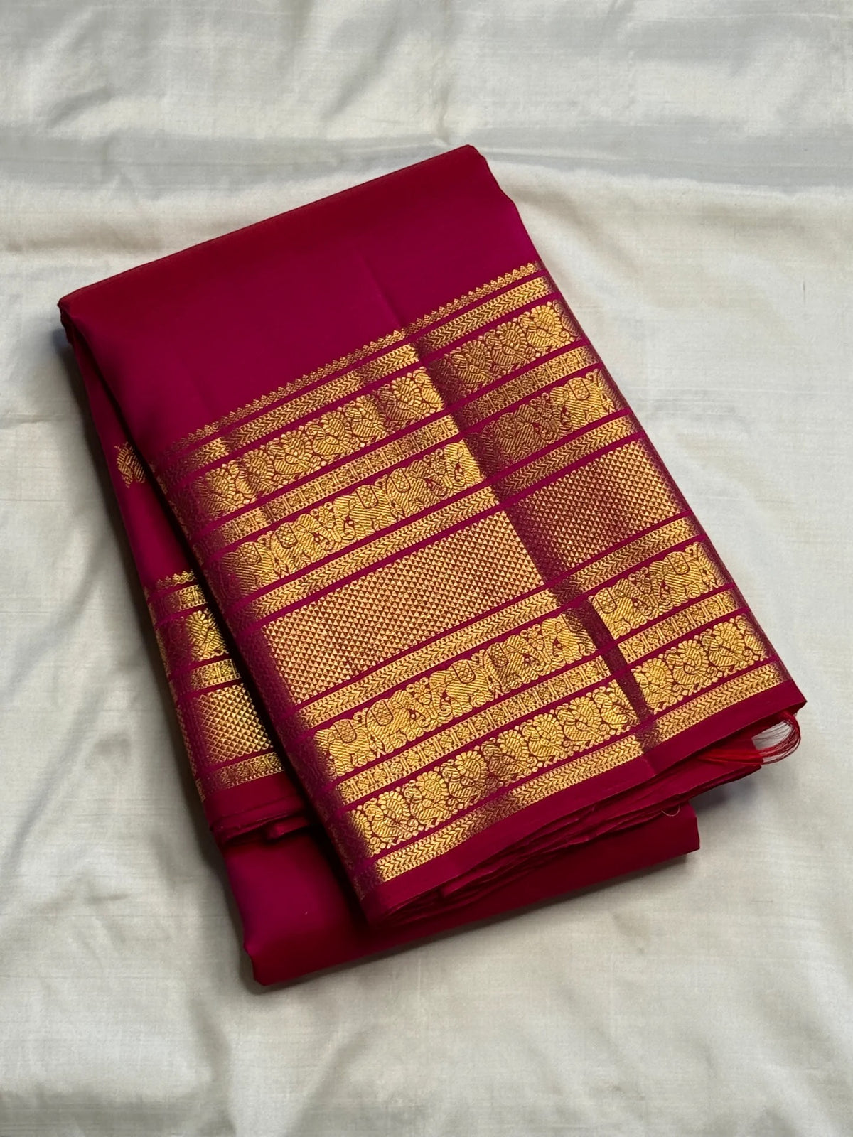 Close view of antique-gold multi-register Varisaipet border on vivid Rani Pink Kanjivaram silk.