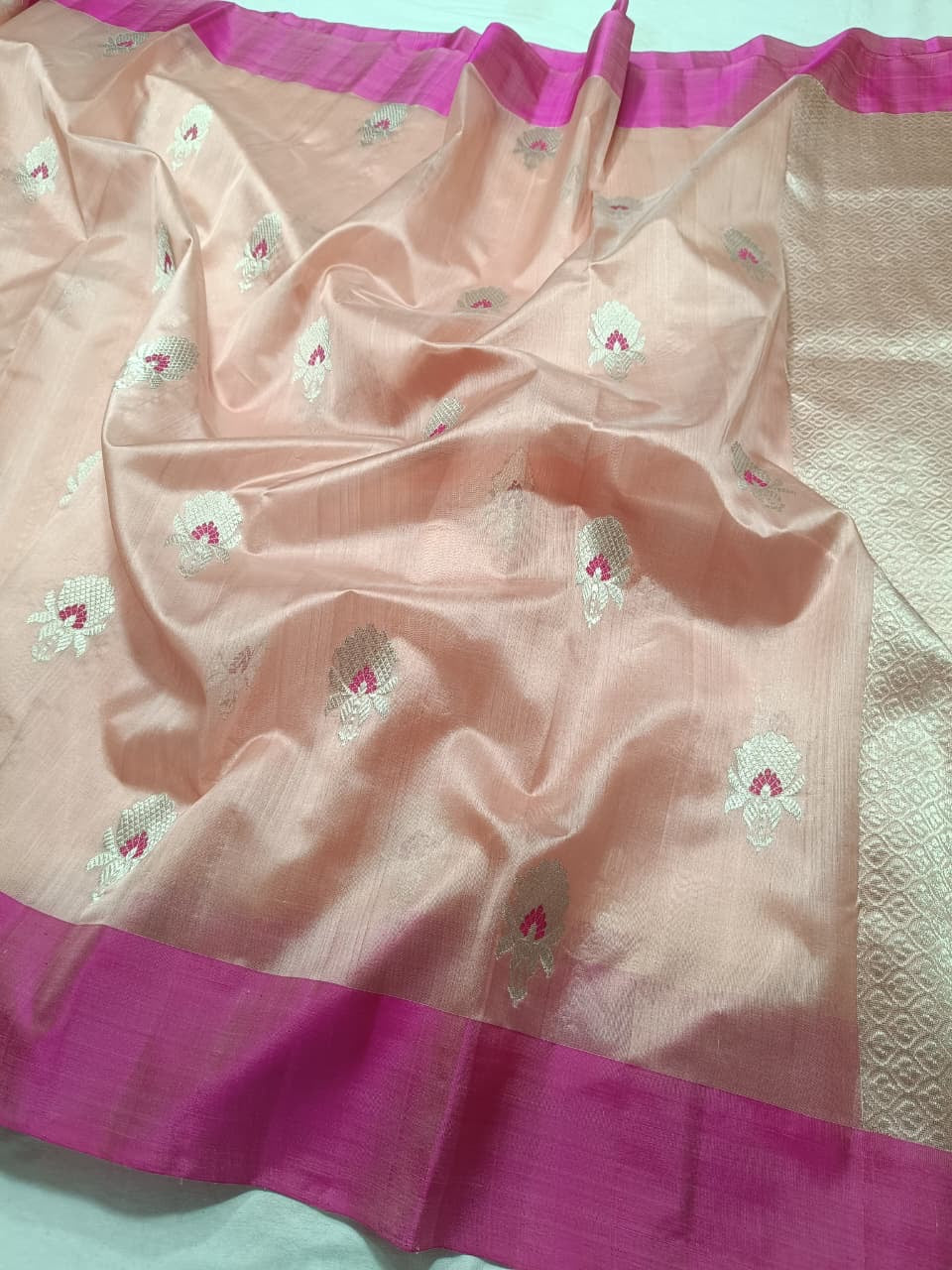 Close-up of the Rani Pink contrast border on a Blush Peach Pattu Silk Chanderi saree
