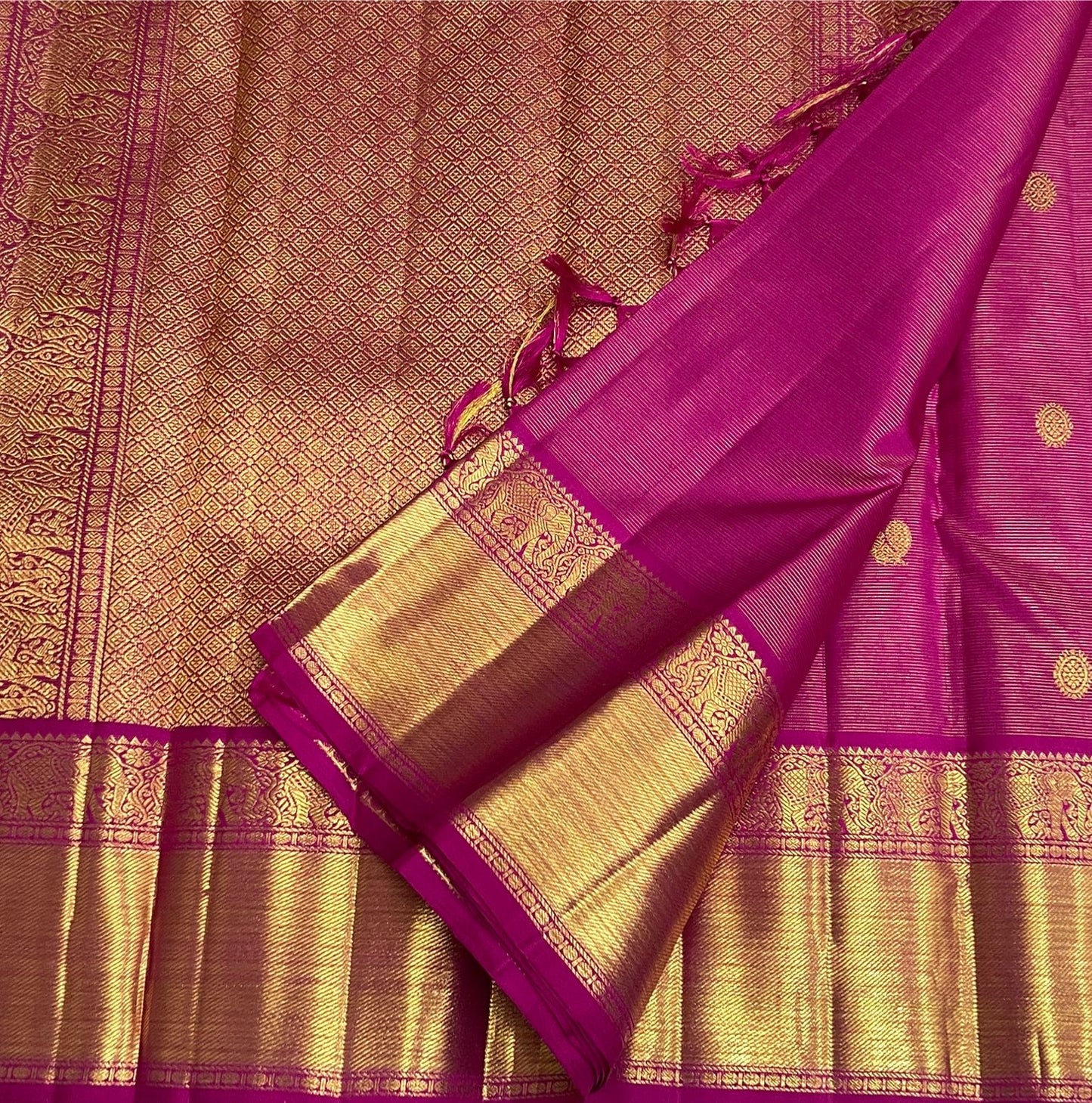 Broad gold zari border detail framed by the vivid Rani Pink silk body.