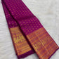 Close view of dense handwoven gold zari buttas across saturated Rani Pink pure silk body.