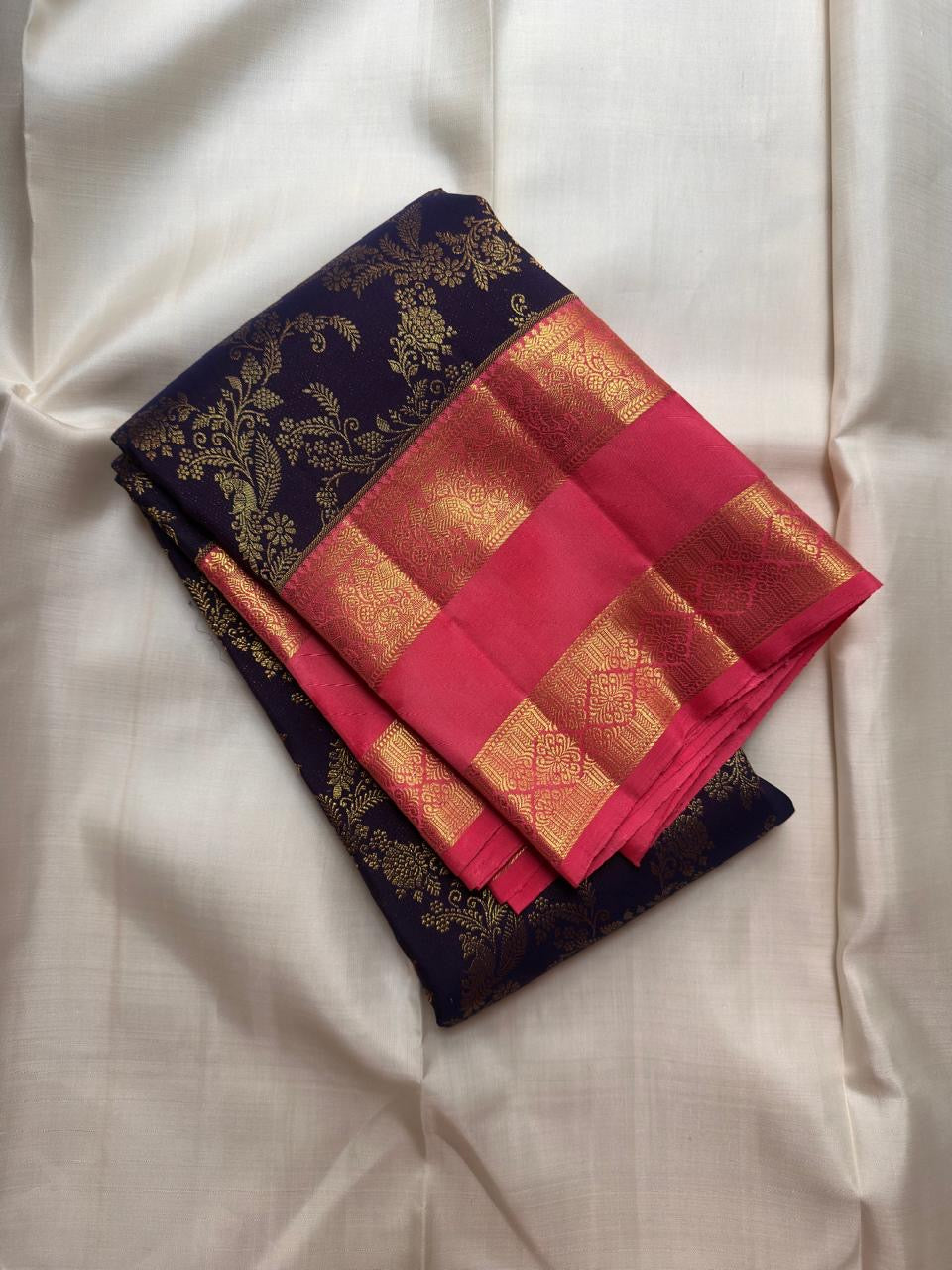 Rani Pink Kanchipuram mundhanai with alternating vertical gold-zari bands, floral panels and larger motifs.