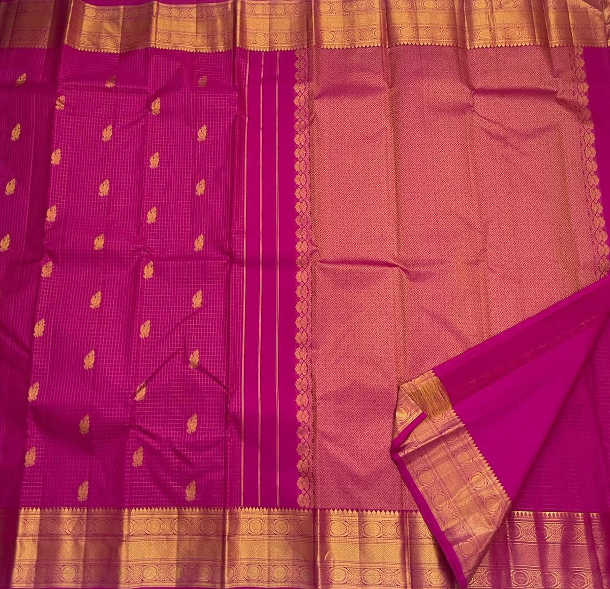 Close-up of the gold medallion border on the Rani pink Kanchipuram silk saree