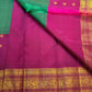 Rani Pink Korvai border with layered warm-gold zari on Emerald Green Kanchipuram saree.
