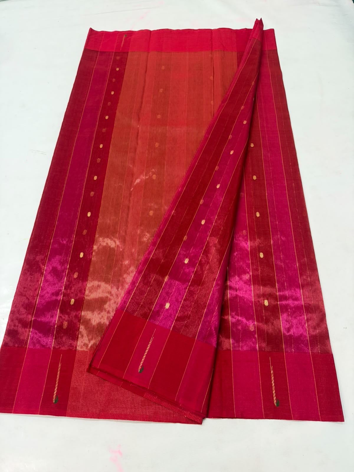 Detail of petite gold buttas along the fine jari stripes on a Rani Pink Tissue Silk Chanderi saree