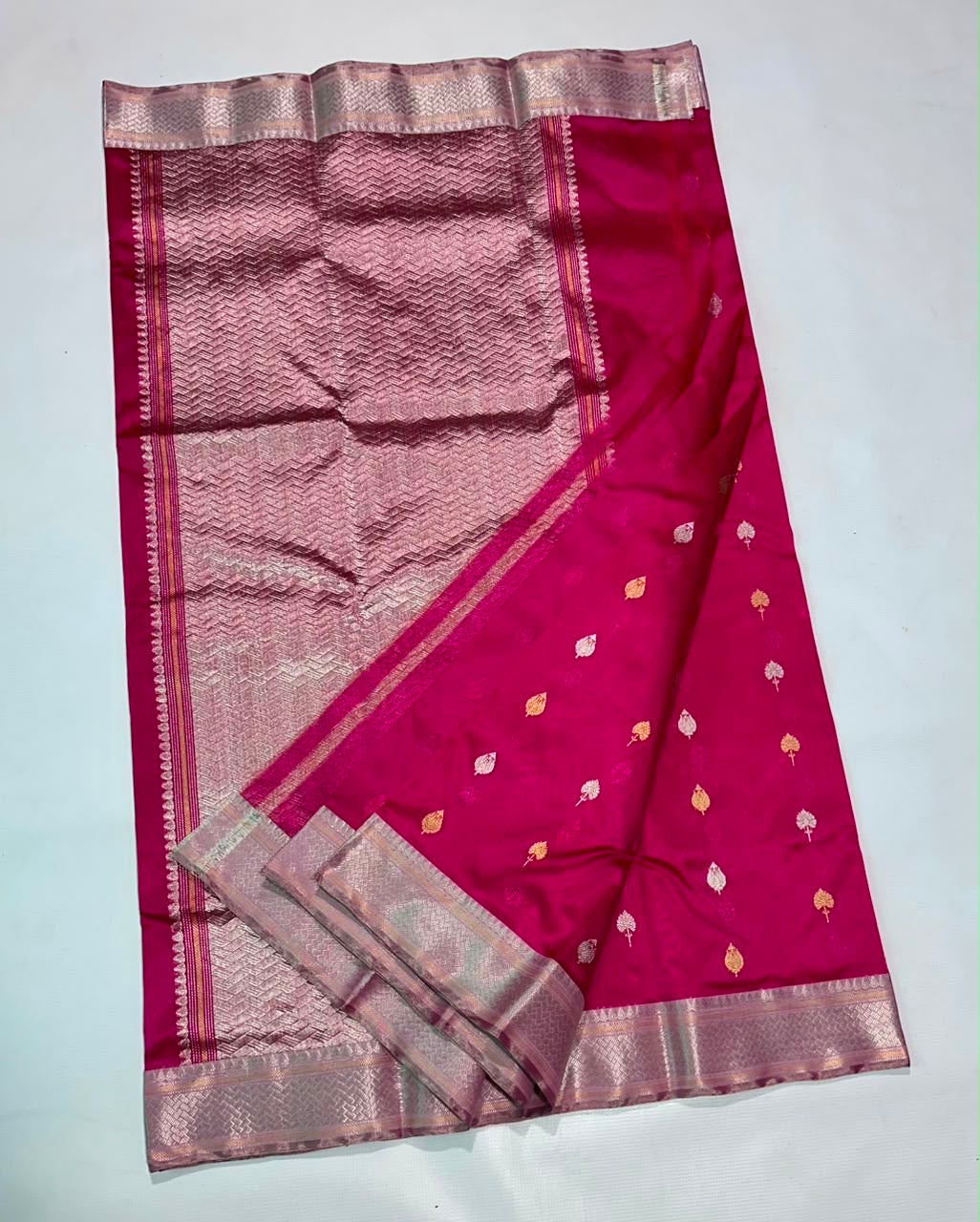 Full view of Rani Pink handloom Chanderi saree with scattered leaf buttas and expansive metallic pallu.