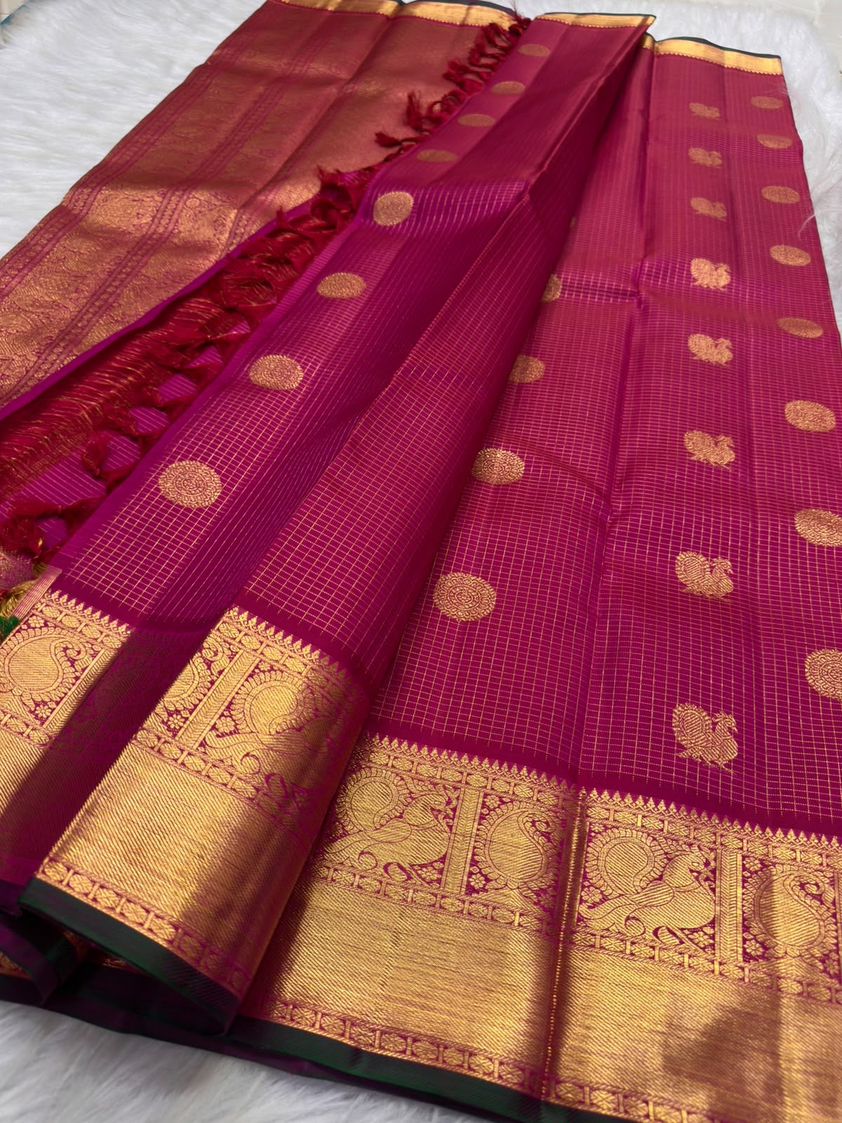 Rani Pink and classic-gold Kanchipuram border finished with a narrow Karum Pachai deep-green selvedge.