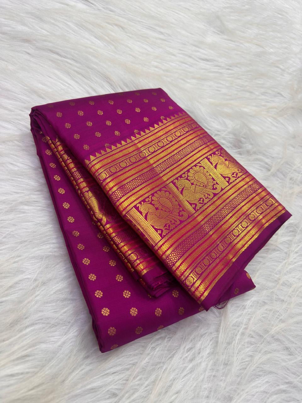 Broad Mayil gold zari border on Rani Pink Kanjeevaram Butta saree.