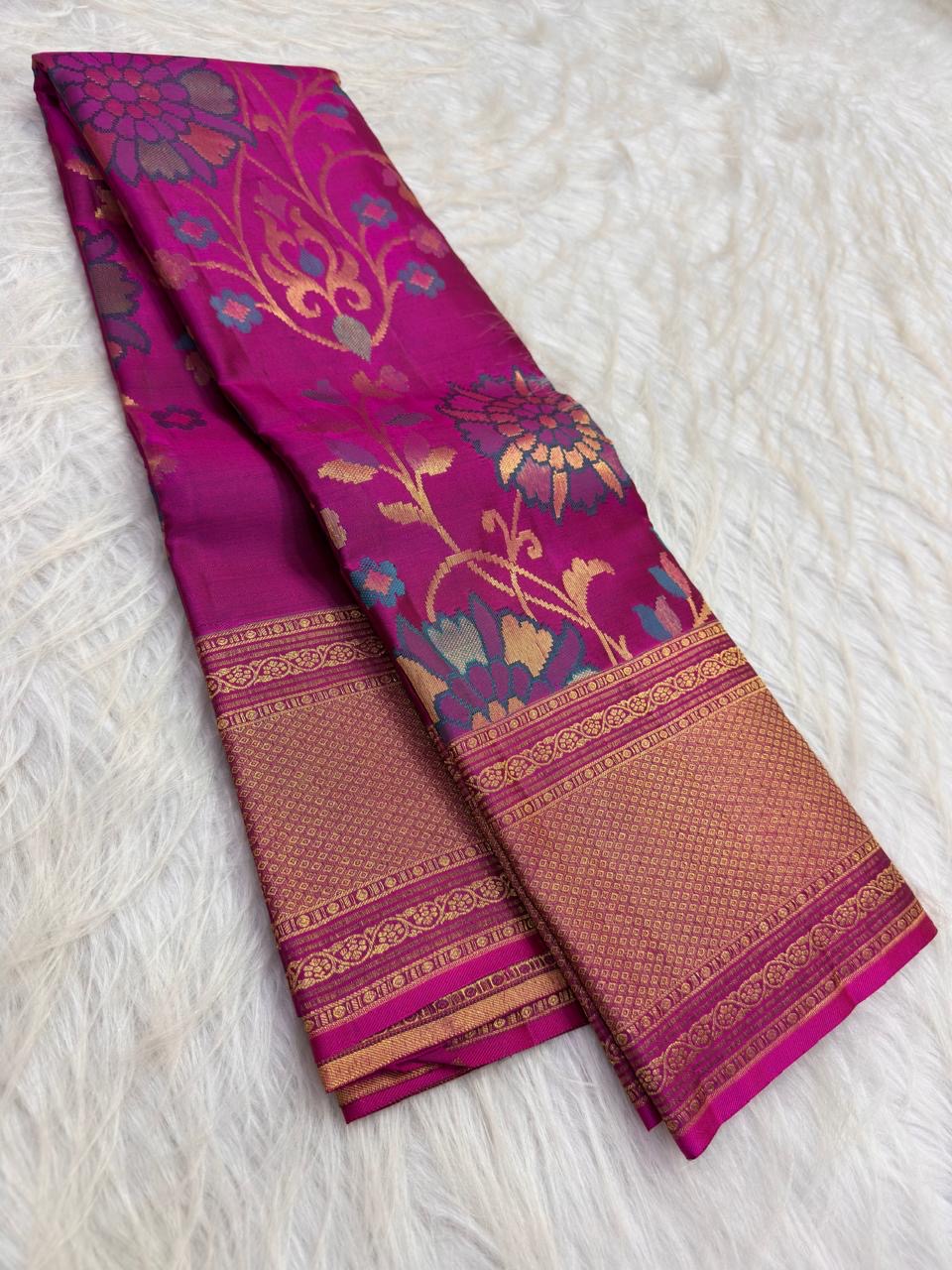 Close view of multicolour woven floral jaal with large blossoms and curling stems on pink silk.