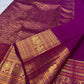 Close view of repeating handwoven peacock motifs framed within traditional gold zari border panels.