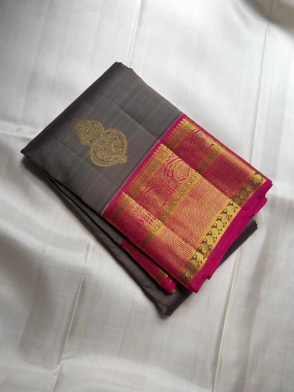 Close view of vibrant Rani Pink Kanchipuram Korvai border and pallu with luminous gold zari detailing.