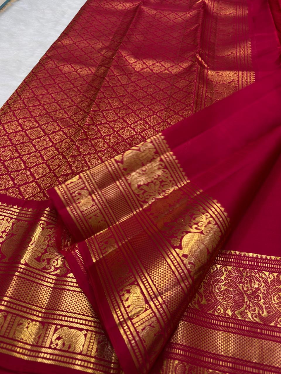 Handwoven sindoor red Kanchipuram silk saree with traditional gold zari buttas.