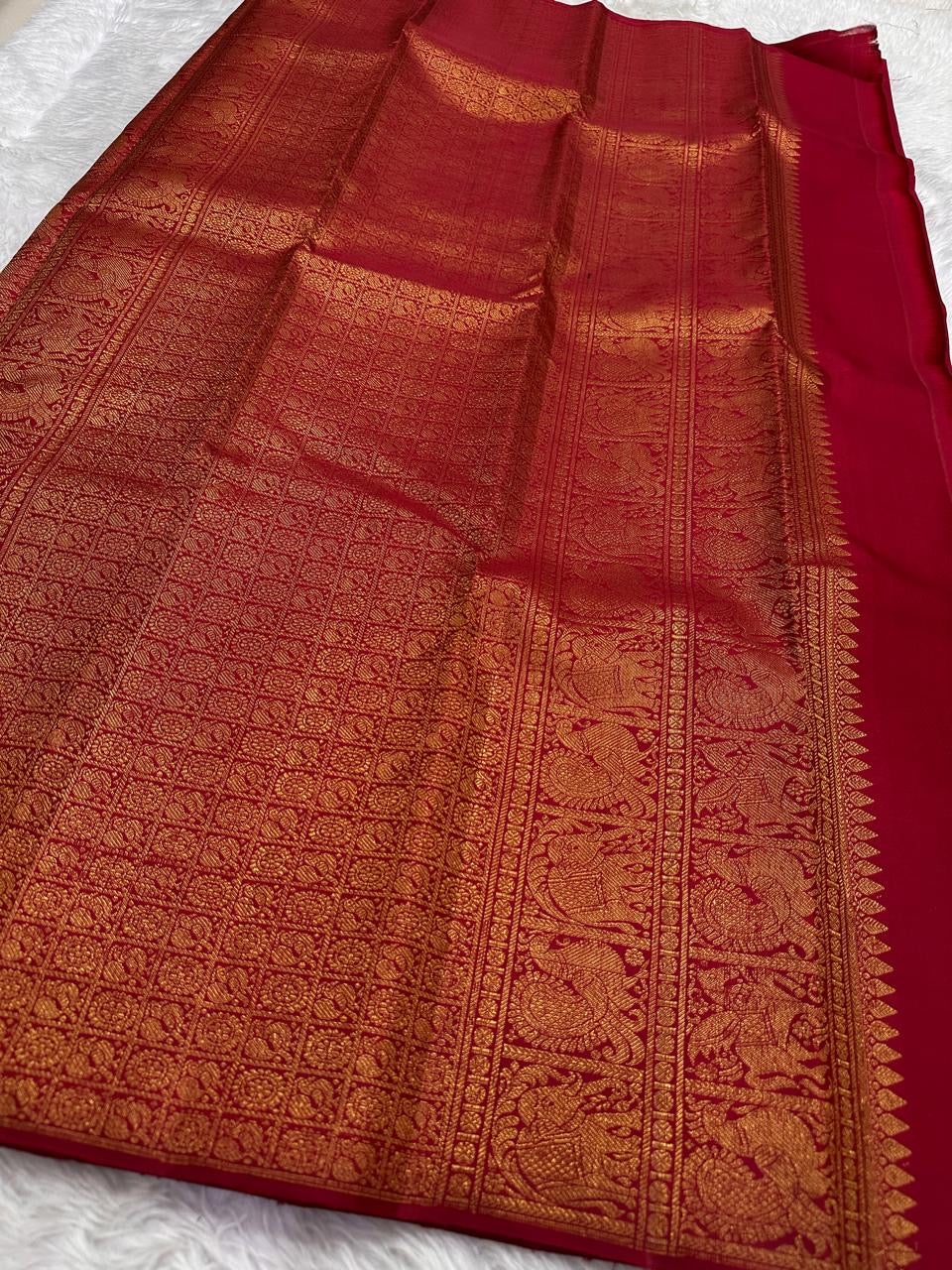 Gold zari border on temple vermillion red Kanjivaram saree