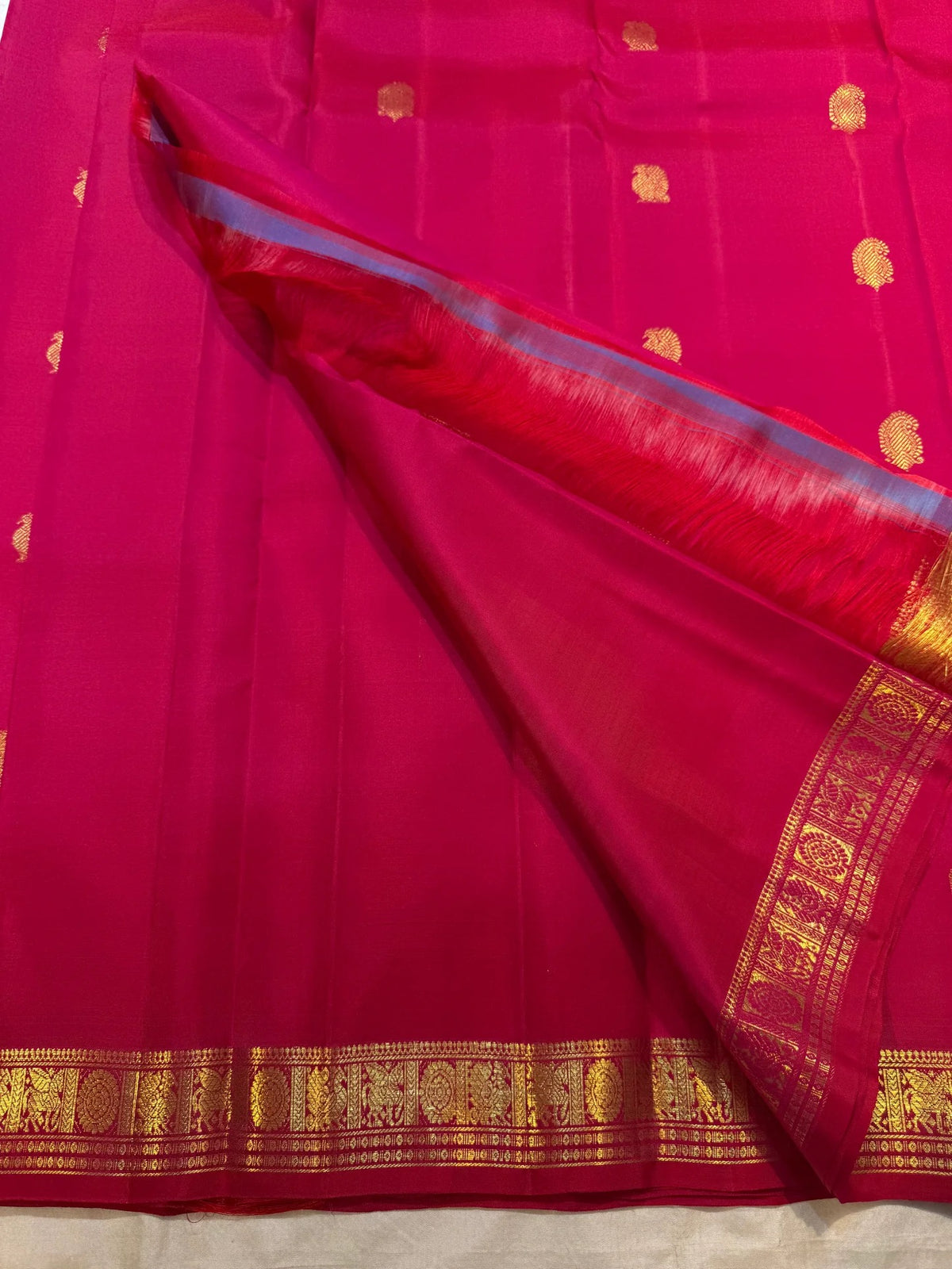 Raspberry Pink pure silk Kanjivaram Butta saree with antique-gold zari motifs.
