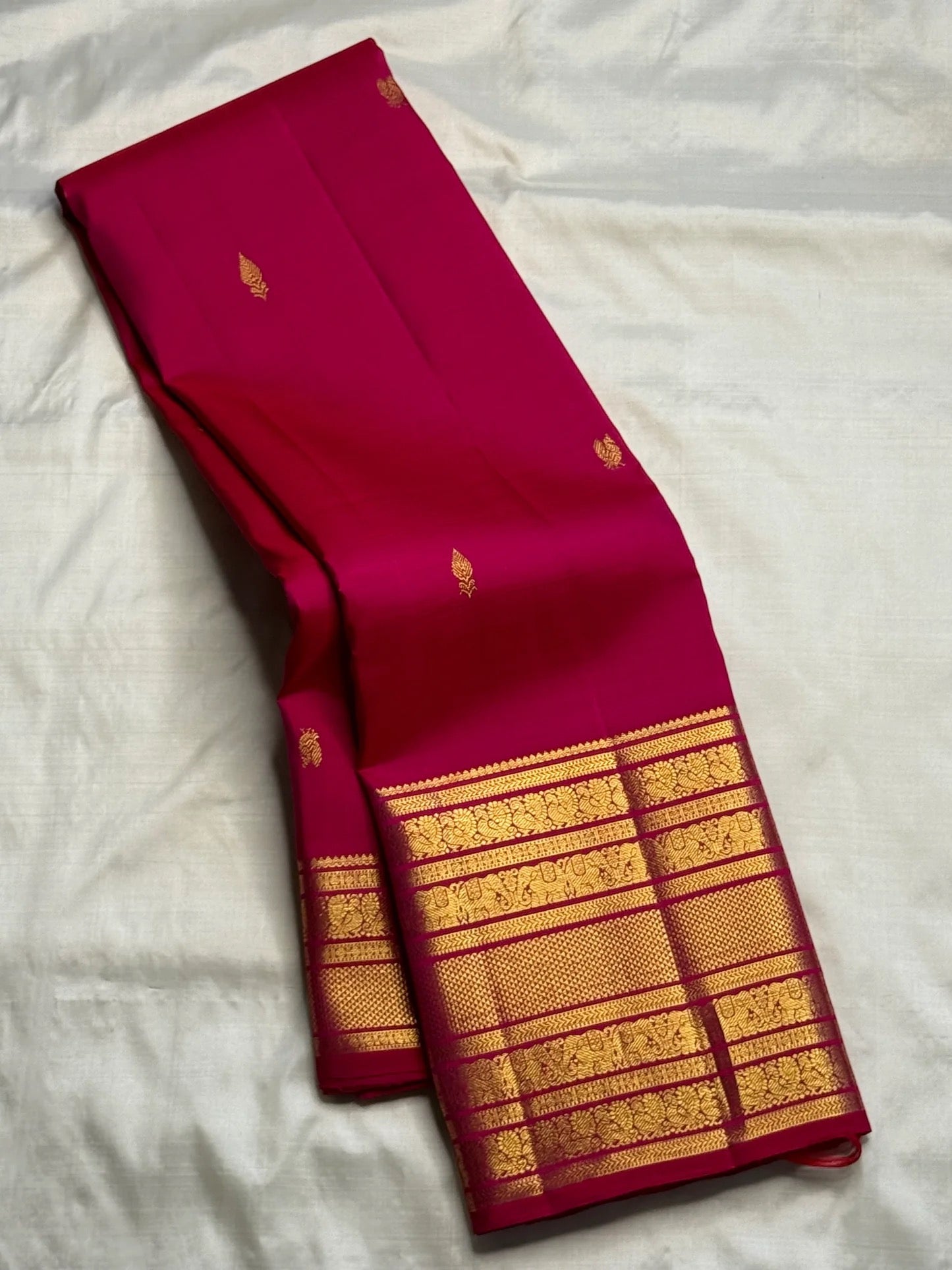Rani Pink handwoven pure silk saree with small gold zari buttas and richly layered Varisaipet border.
