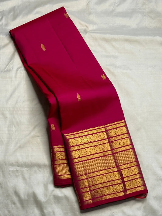Rani Pink handwoven pure silk saree with small gold zari buttas and richly layered Varisaipet border.