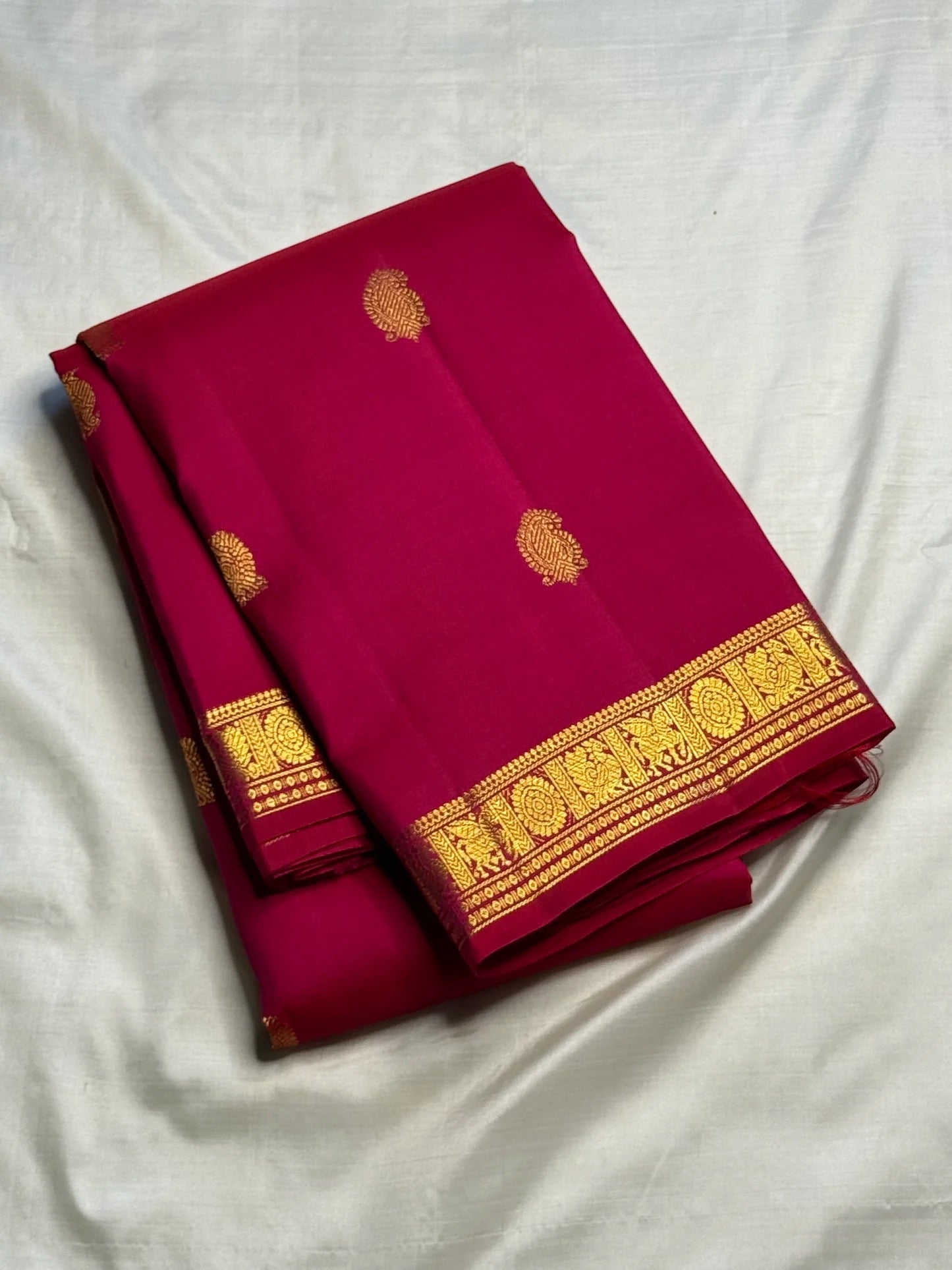 Close view of antique-gold zari buttas woven on Raspberry Pink Kanjivaram silk.