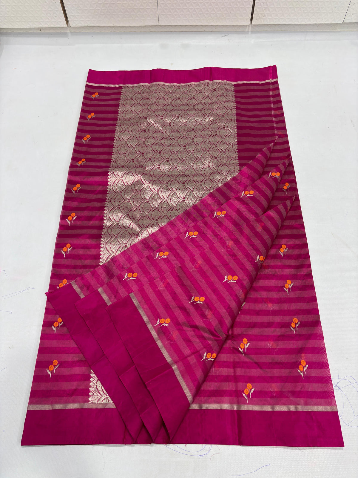 Full view of Raspberry Pink handloom Chanderi saree showing tonal striped body and expansive patterned metallic pallu.