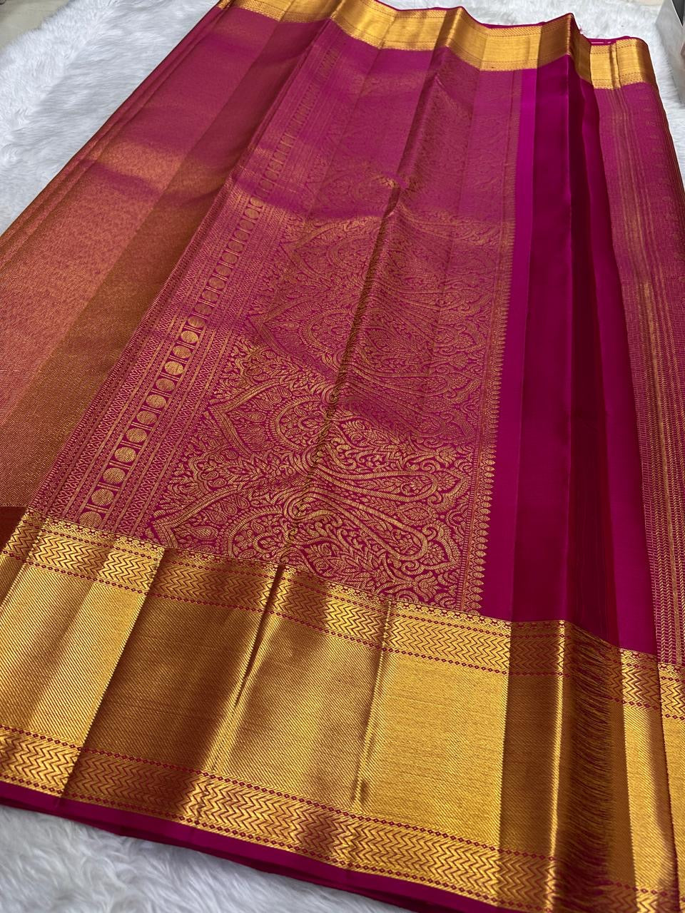 Raspberry pink Kanjeevaram saree with grand antique-gold zari border, close view