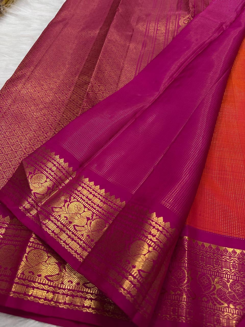 Close view of handwoven gold zari buttas on orange Vairaoosi silk