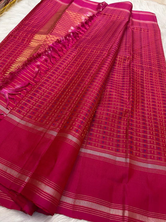 Close-up of gold zari buttas in the 1000 Butta pattern on the raspberry pink KanchiPattu saree.
