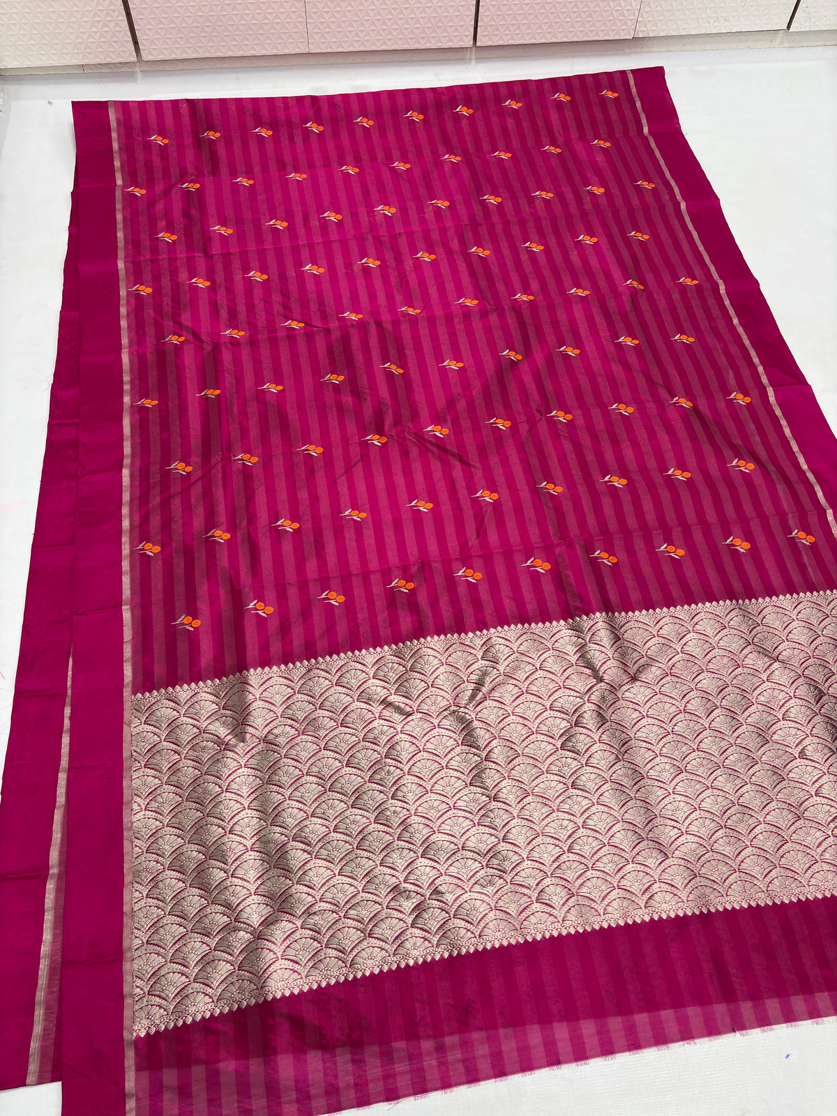 Raspberry Pink Pattu Silk Chanderi saree pallu with expansive metallic field and repeating scalloped floral pattern.