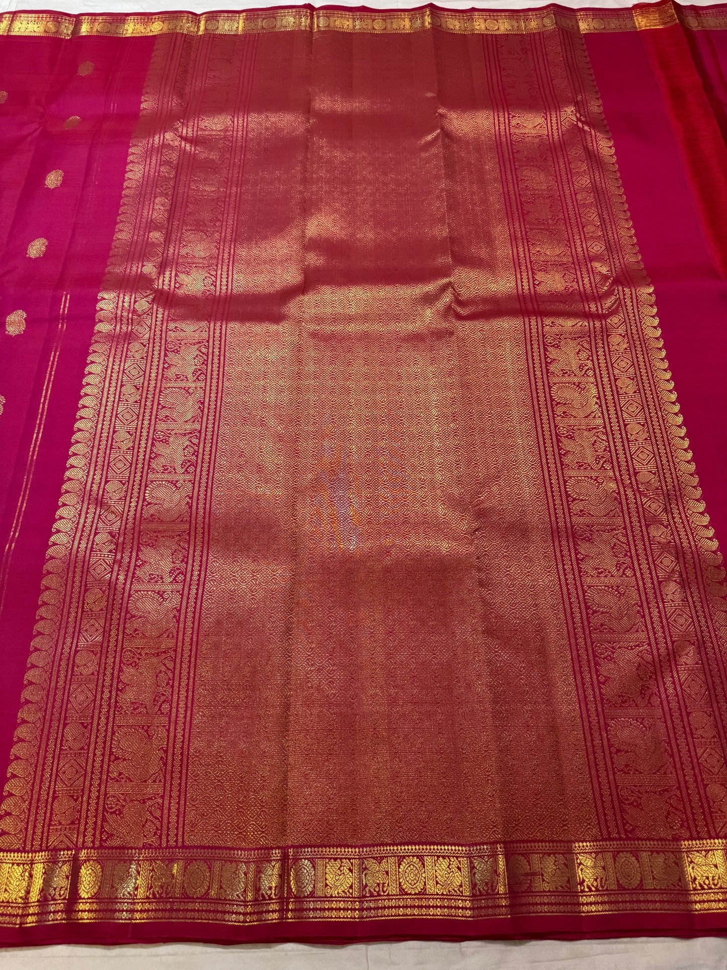 Raspberry Pink Kanchipuram silk saree with individually spaced gold zari buttas.