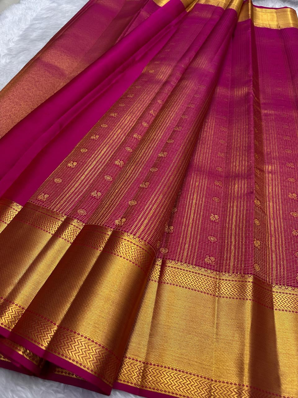 Pallu detail of raspberry pink Kanjeevaram saree with antique-gold zari chevron border