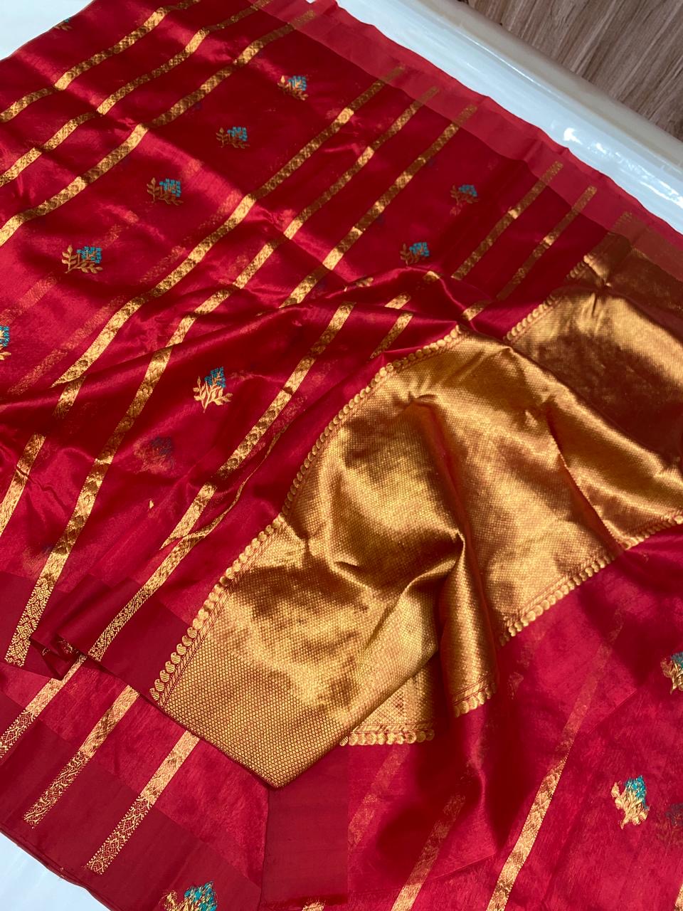 Raspberry red Pattu Silk Chanderi saree with broad gold-toned woven pallu and turquoise floral accents