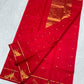 Raspberry red Chanderi silk saree showing peacock motif border with fine gold-toned zari and green detailing
