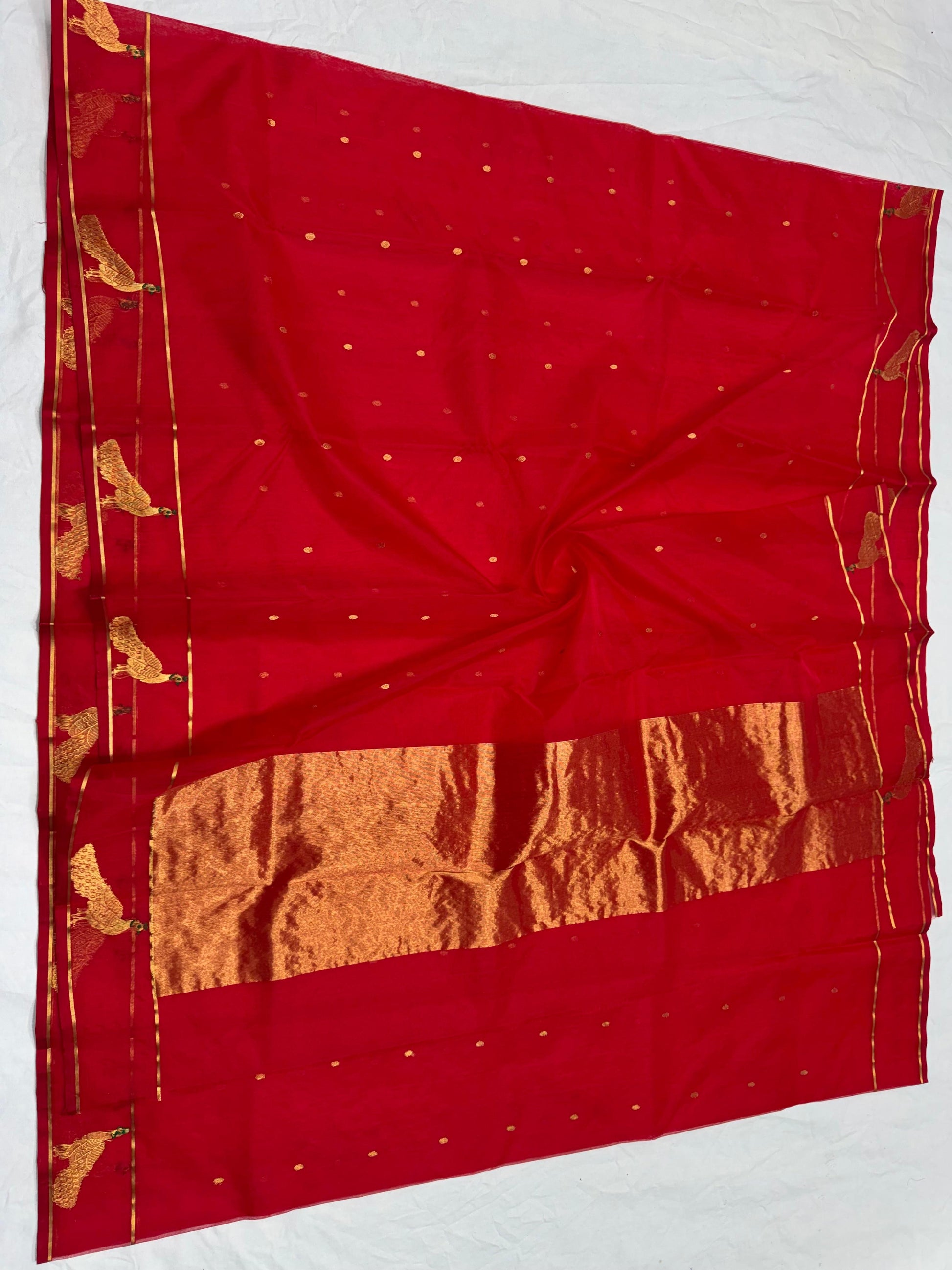 Folded raspberry red Chanderi silk saree showing gold buttas and woven peacock border