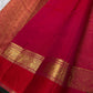Close-up of raspberry pink and vermilion Pure Silk Kanchipuram saree with gold zari elephant and peacock border motifs.
