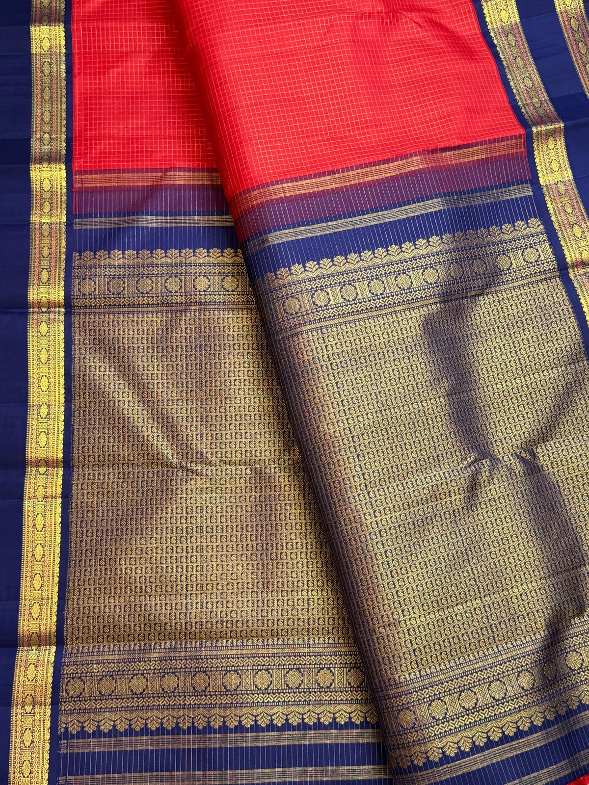 Deep neelam-blue pallu and border with Rudhraksham-inspired detailing on a deep vibrant red Kanchipuram silk saree.