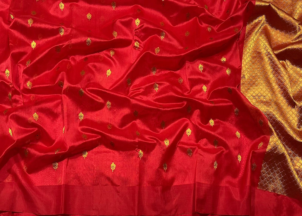 Crimson silk saree featuring silver flowers and leafy vines