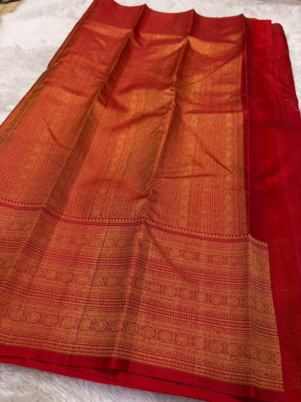 Red pallu with cascading antique gold zari motif array — floral, geometric, and medallion bands