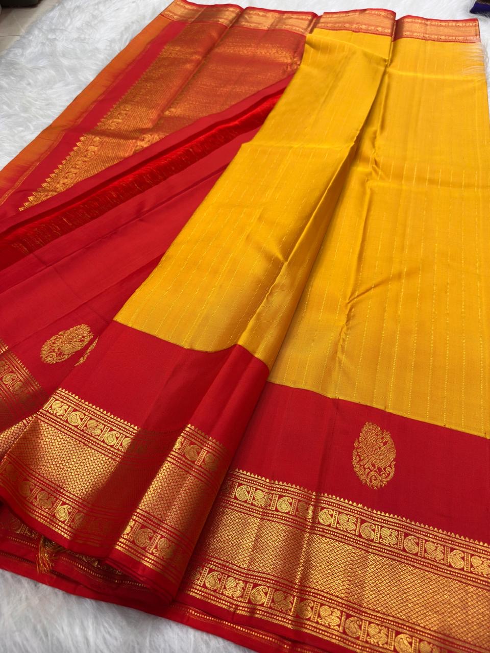 Vermilion Red gold-zari border on Turmeric Yellow Kanjivaram saree.