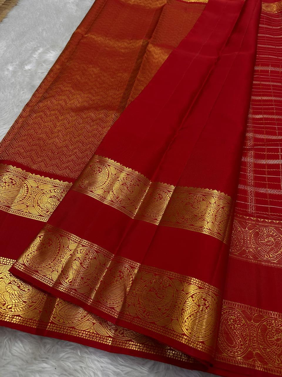 Close view of Crimson Red Kanchipuram silk with a broad gold zari Sorgavasal Mayil and Manga border and richly woven pallu.