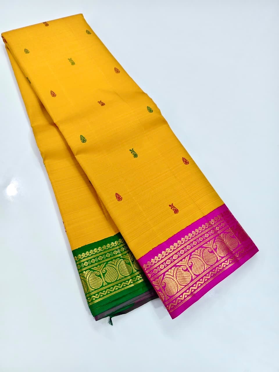 Close view of alternating Arakku-red and green buttas on the yellow silk body