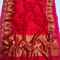 Folded red Pattu Silk Chanderi saree showing petite gold buttas and richly woven multicolour floral border