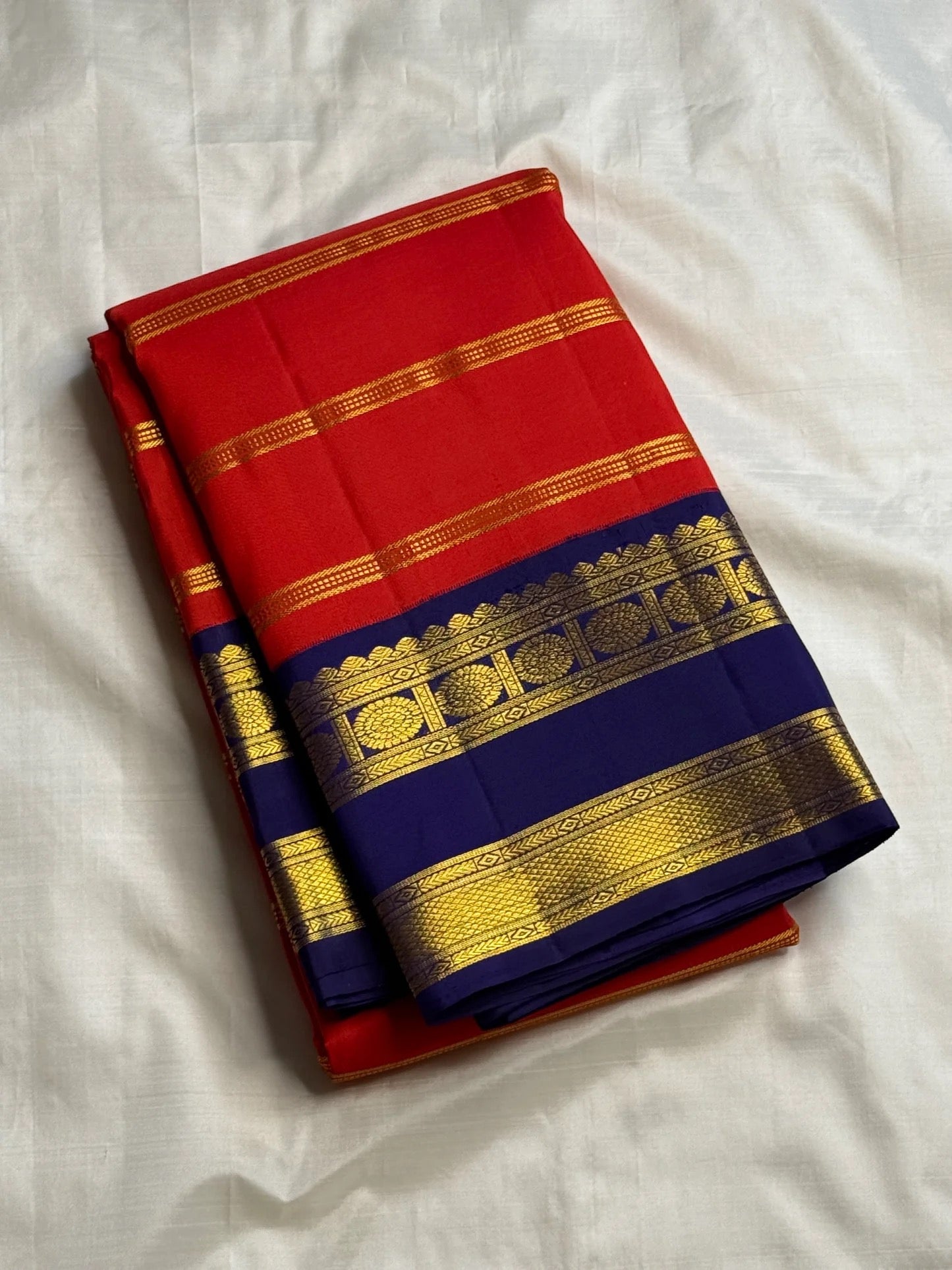 Red Kanchipuram silk saree with royal blue rettapet border folded view