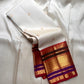 Draped ivory Pure Kanchipuram silk saree showing scattered gold buttas and a broad gold zari border with red and purple accents