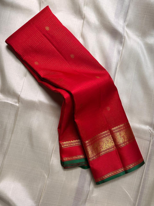 Vibrant red Kanchipuram silk saree green selvedge traditional gold zari border detail