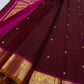 Saree body in deep red with gold buttas and wide zari woven border beside magenta pallu.