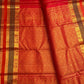 Radiant vermilion red reminiscent of temple kumkum pure silk Kanchipuram saree, vermilion red yaanai peacock butta silk; traditional Zari Kattam weave.