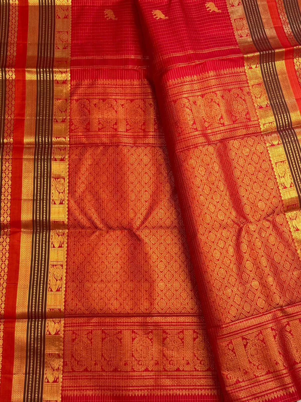 Radiant vermilion red reminiscent of temple kumkum pure silk Kanchipuram saree, vermilion red yaanai peacock butta silk; traditional Zari Kattam weave.