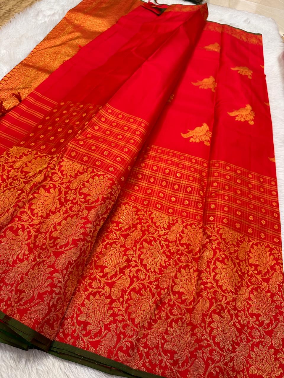Individually woven perched-bird gold zari buttas across the brilliant red Kanjivaram silk body.
