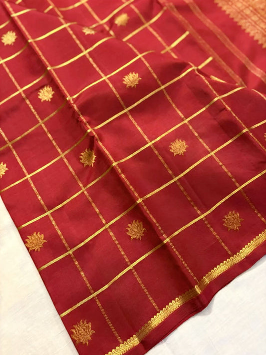 Deep red Kanjivaram silk saree featuring classic gold checkered zari weave and floral buttas