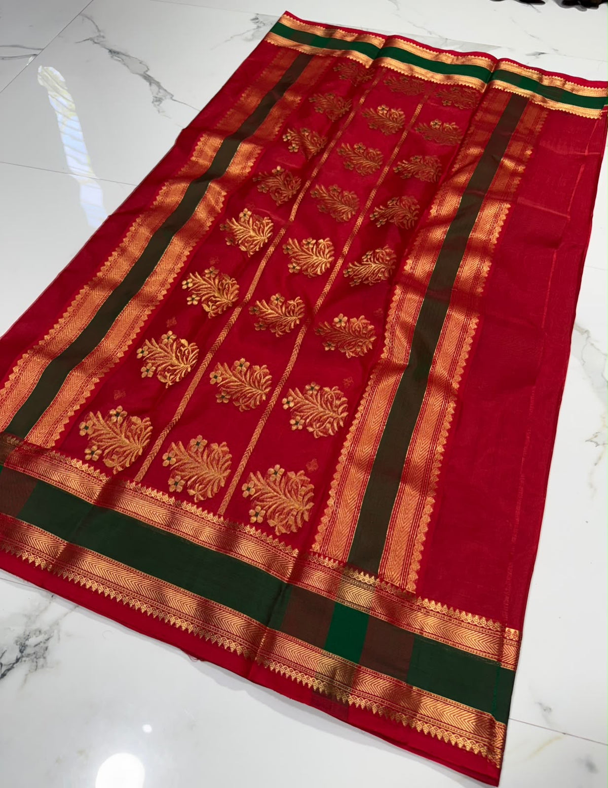 Pallu of crimson red Katan Silk Chanderi saree with rows of gold botanical motifs and forest green zari bands